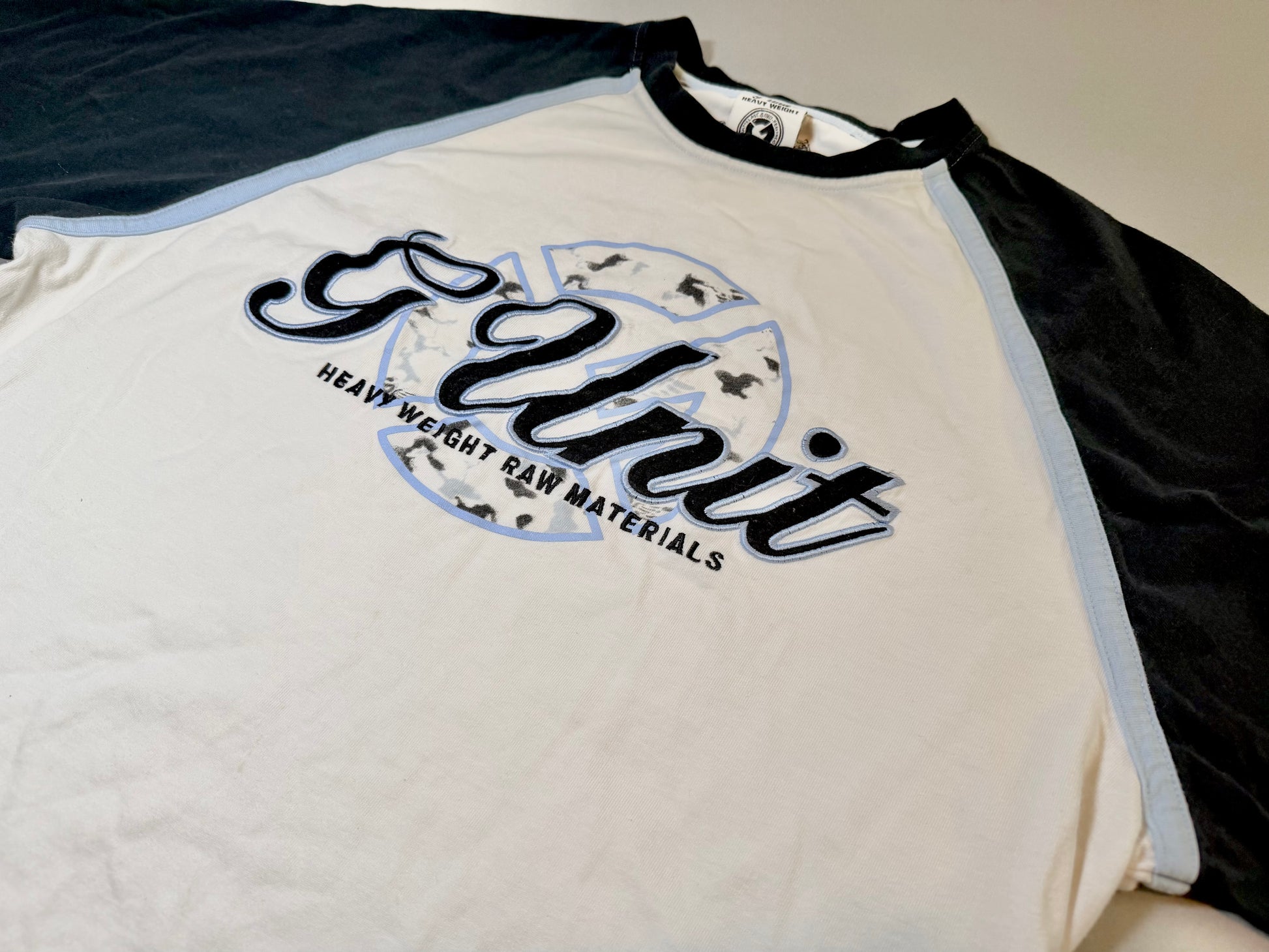 Close-up of the embroidered G-Unit chest graphic with Heavy Weight Raw Materials branding.