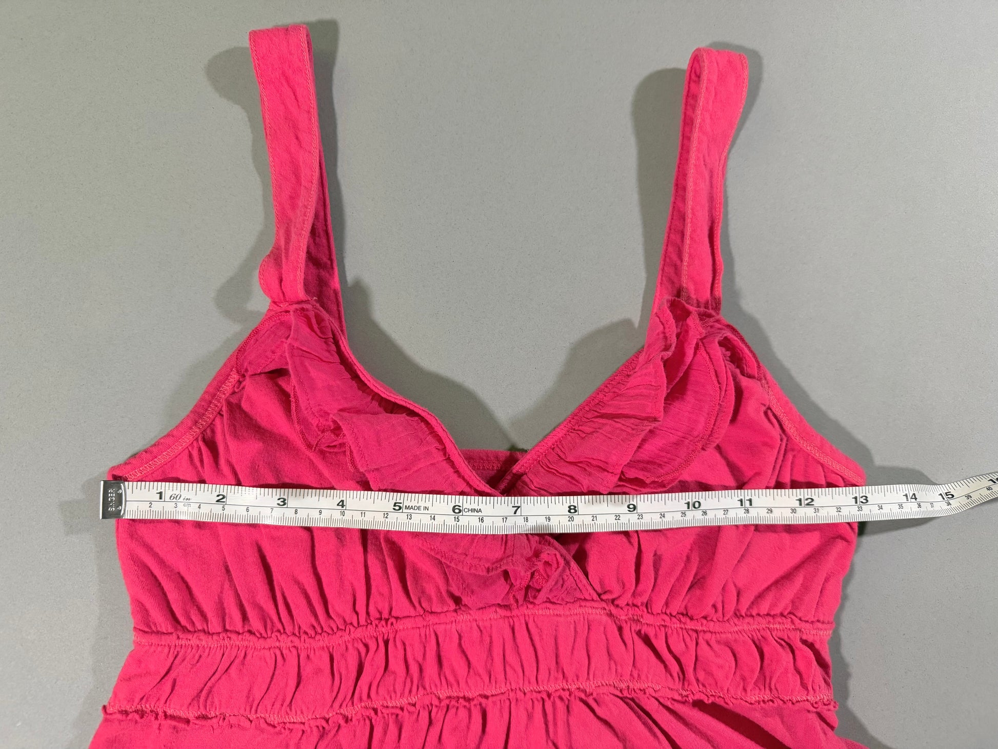 Bust measurement shown across the front of the vintage coral pink Hollister babydoll tank top.