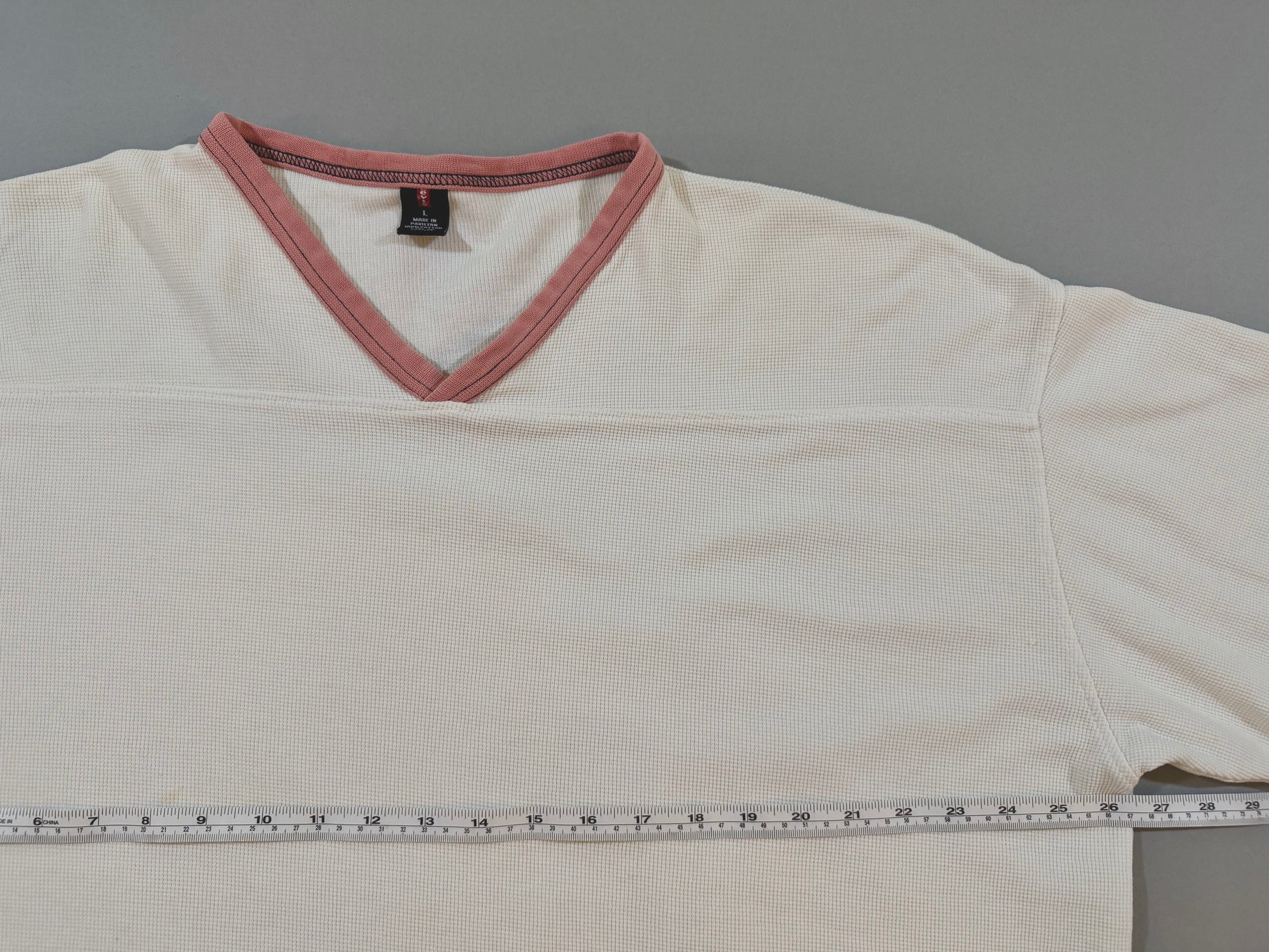 Front upper detail of the vintage Levi’s thermal showing the V-neck, football yoke seam, and contrast salmon trim.