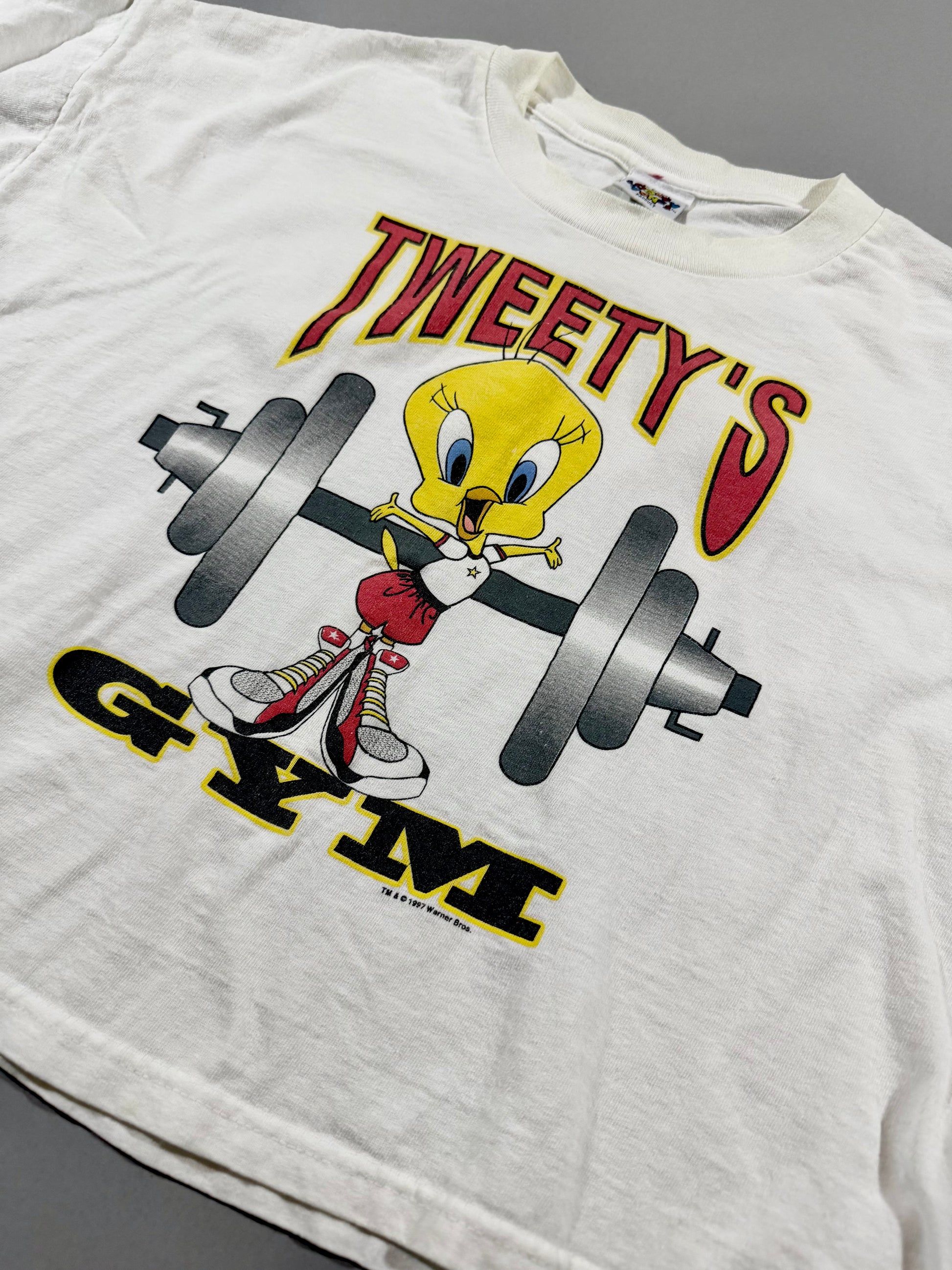 Close-up of officially licensed Tweety lifting a barbell graphic with “Tweety’s Gym” text.