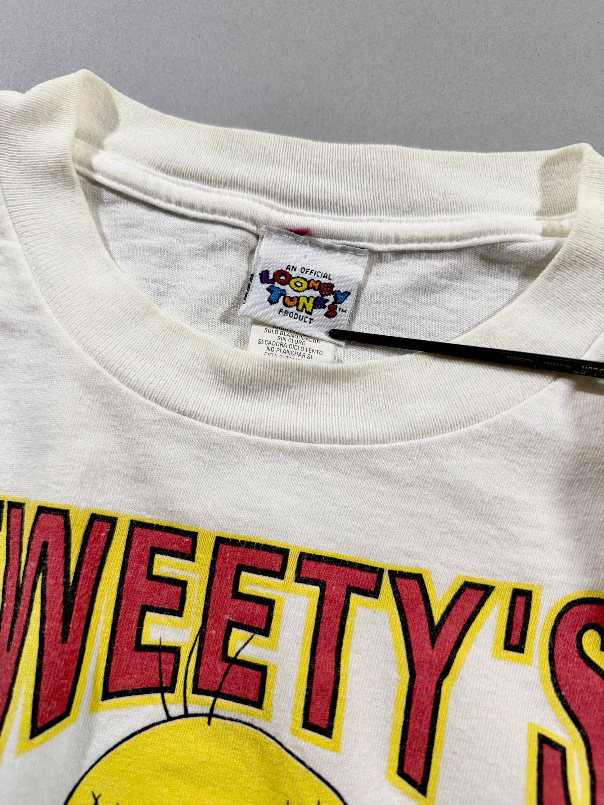 Close-up of Official Looney Tunes neck tag on vintage graphic T-shirt.