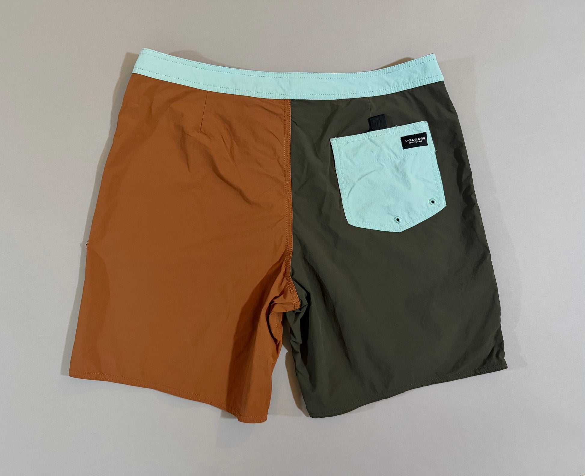 Back view of Volcom quick-dry boardshorts with rear pocket and color block design. 