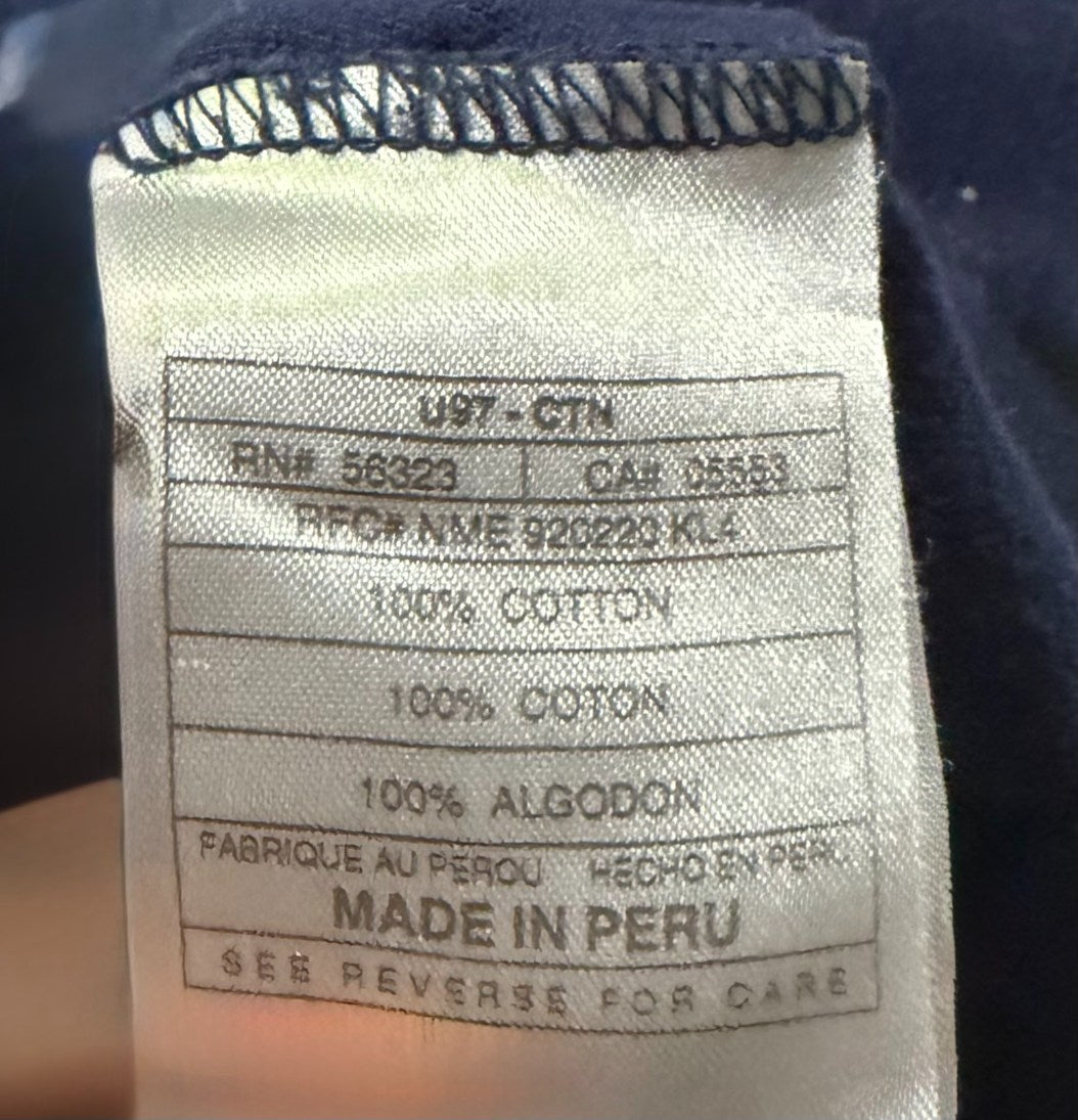 Close-up of vintage Nike shirt’s sewn-in label showing details like manufacturing year 1997, '100% COTTON' and 'MADE IN PERU'