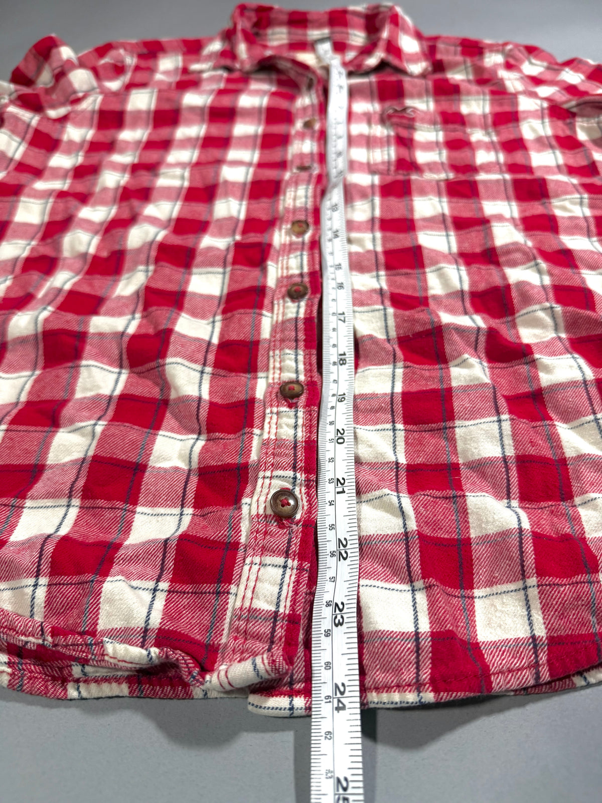Photo of Hollister plaid button up showing length measurement. 
