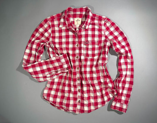 Straightforward photo of a women’s/juniors’ red buffalo plaid flannel shirt from Hollister. 