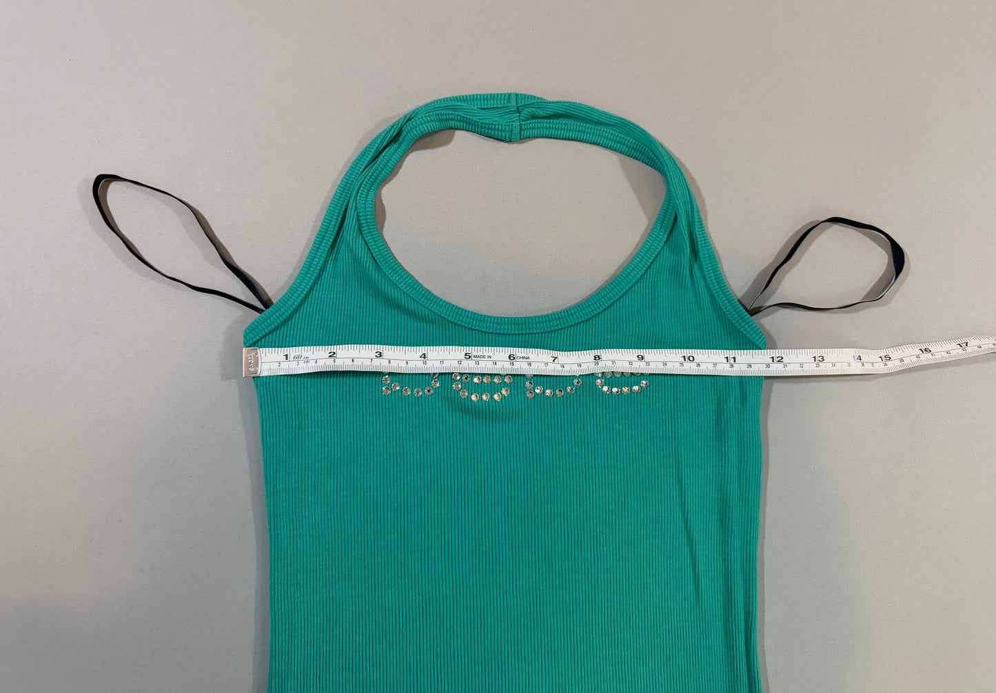 Bust measurement of the vintage Bebe turquoise halter mini dress shown laid flat.