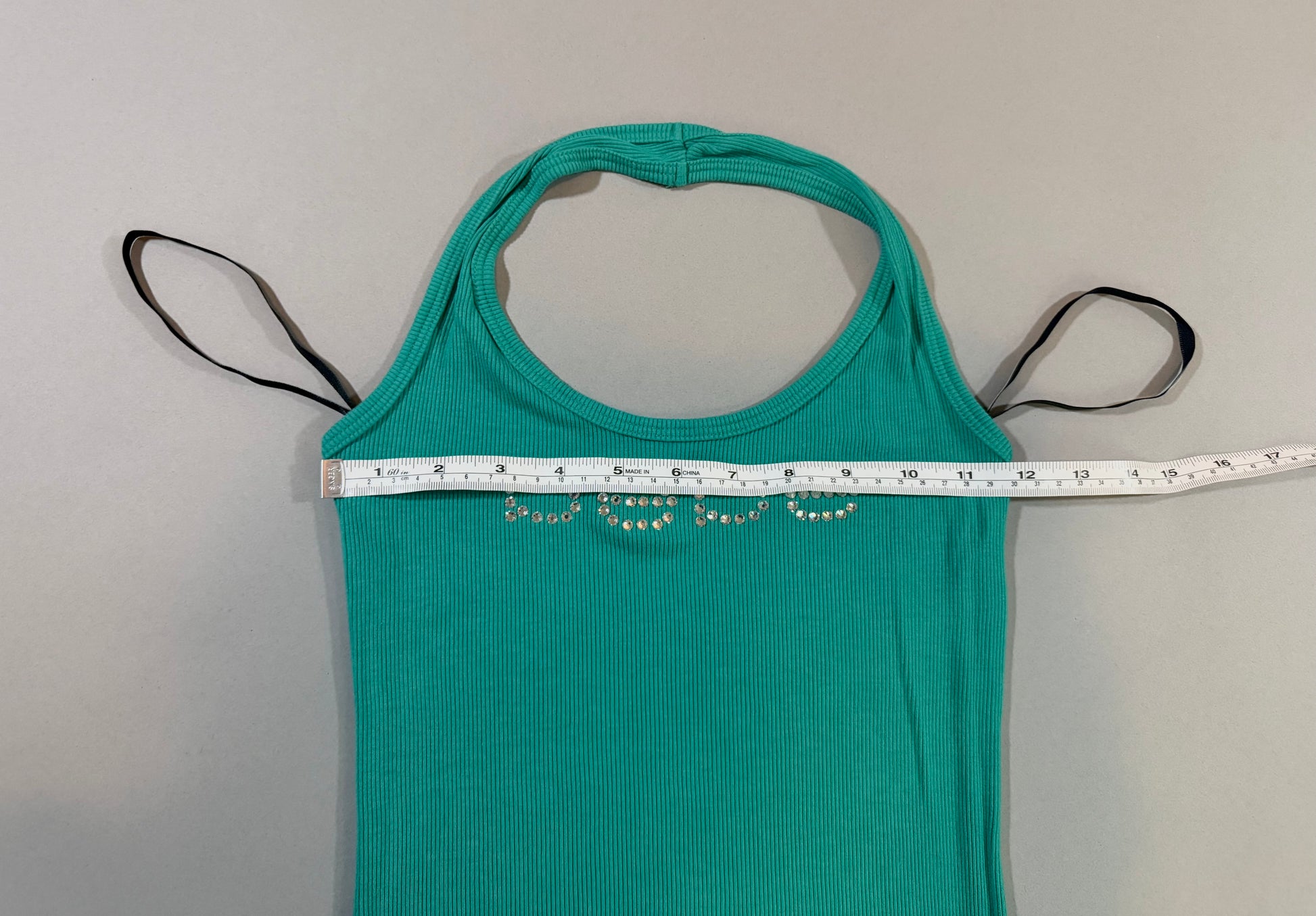 Bust measurement of the vintage Bebe turquoise halter mini dress shown laid flat.
