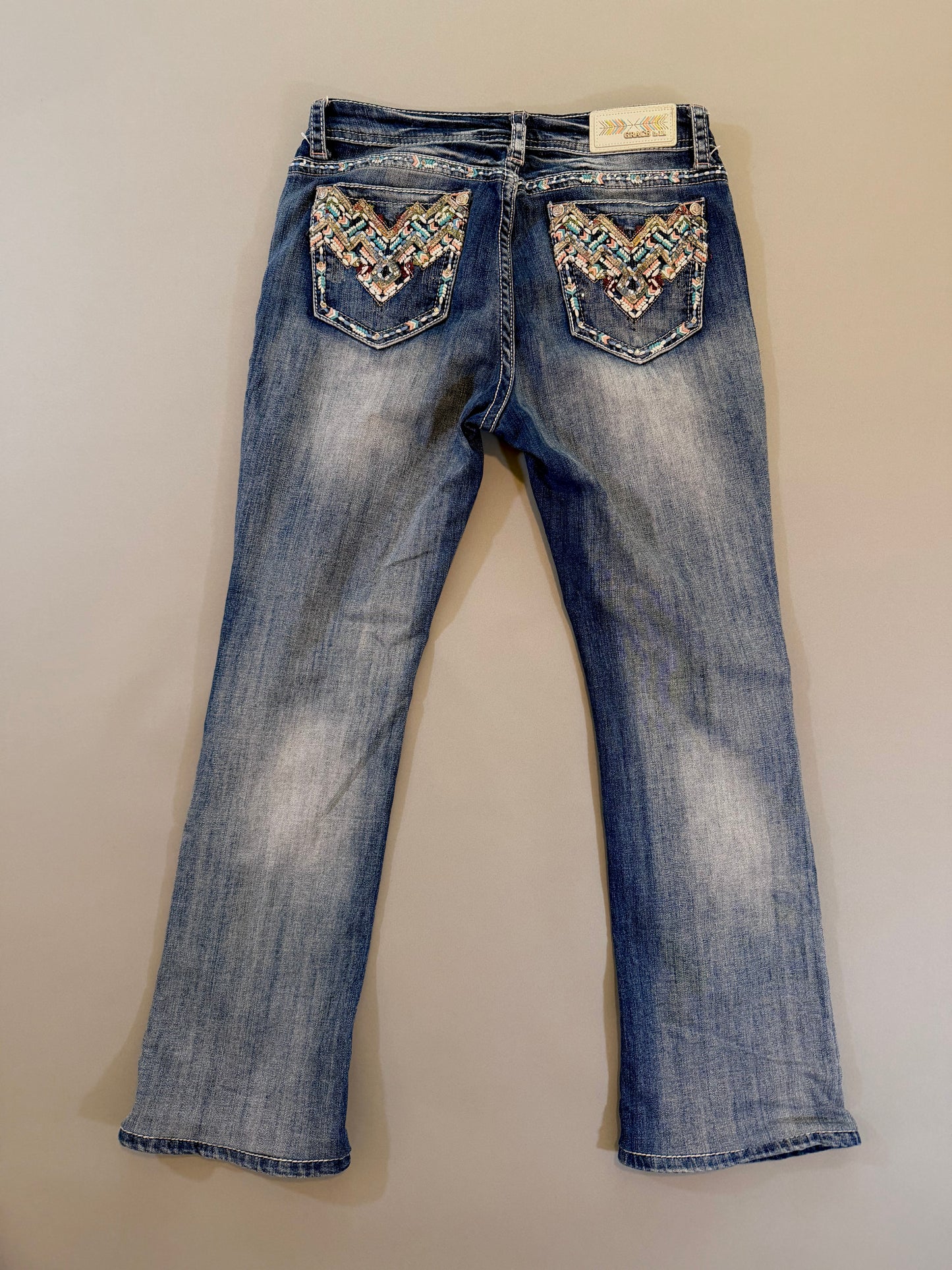 Back of y2k grace in LA boho denim jeans showing pocket embroidery and rhinestone embellishments 