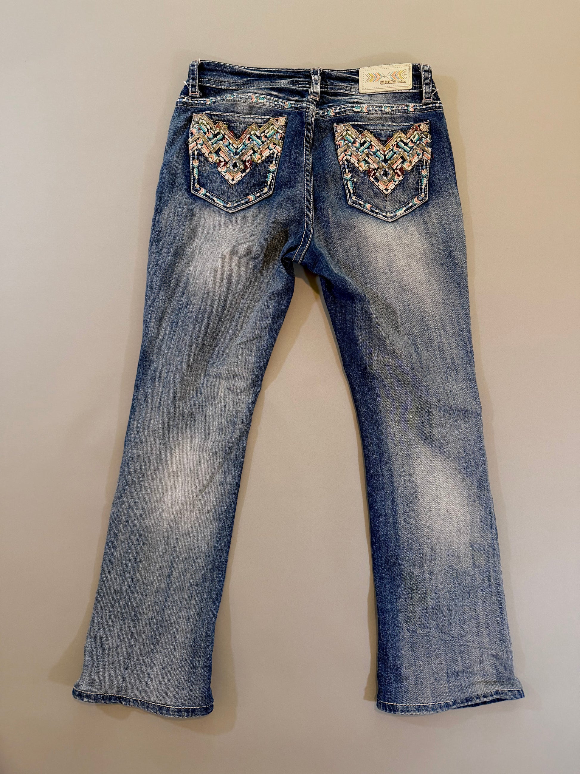 Back of y2k grace in LA boho denim jeans showing pocket embroidery and rhinestone embellishments 