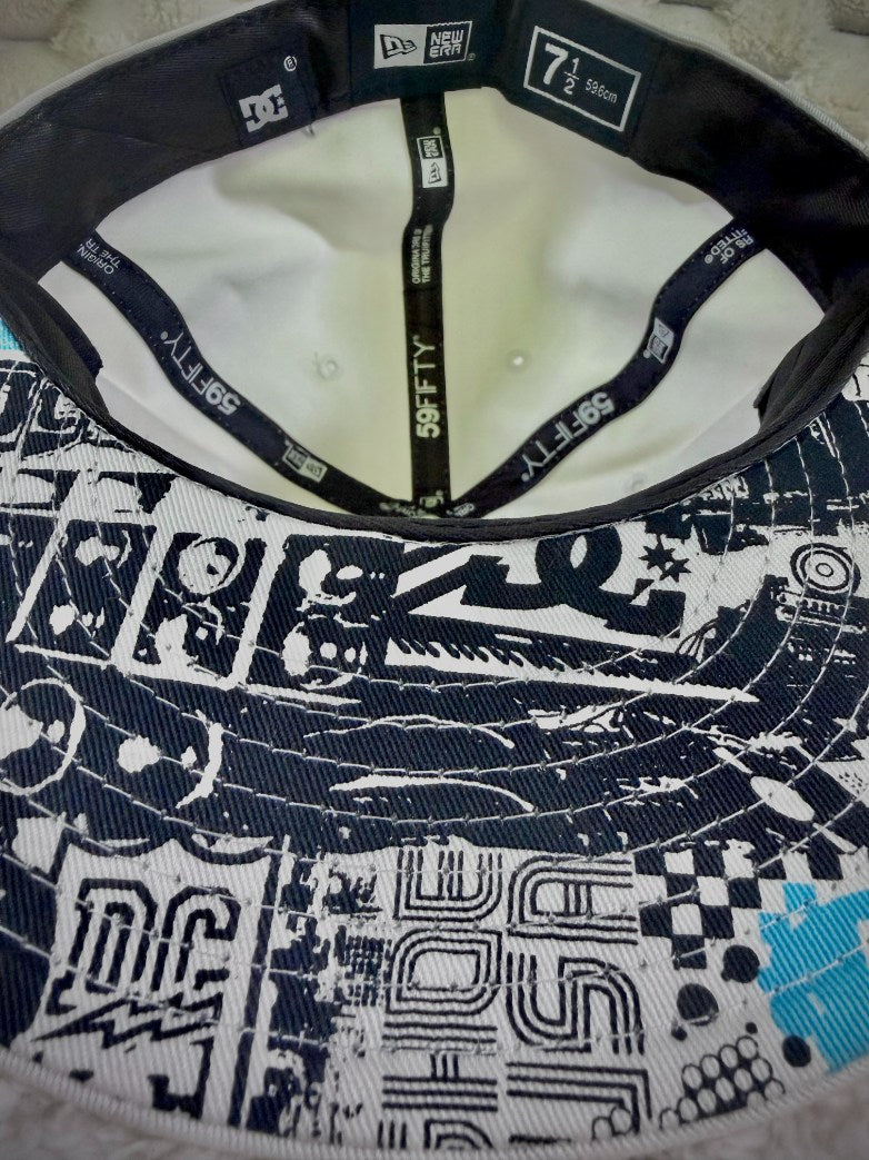 Interior view of vintage DC Shoes New Era 59FIFTY cap showing branded interior taping and black, white and blue graphic underside of brim.