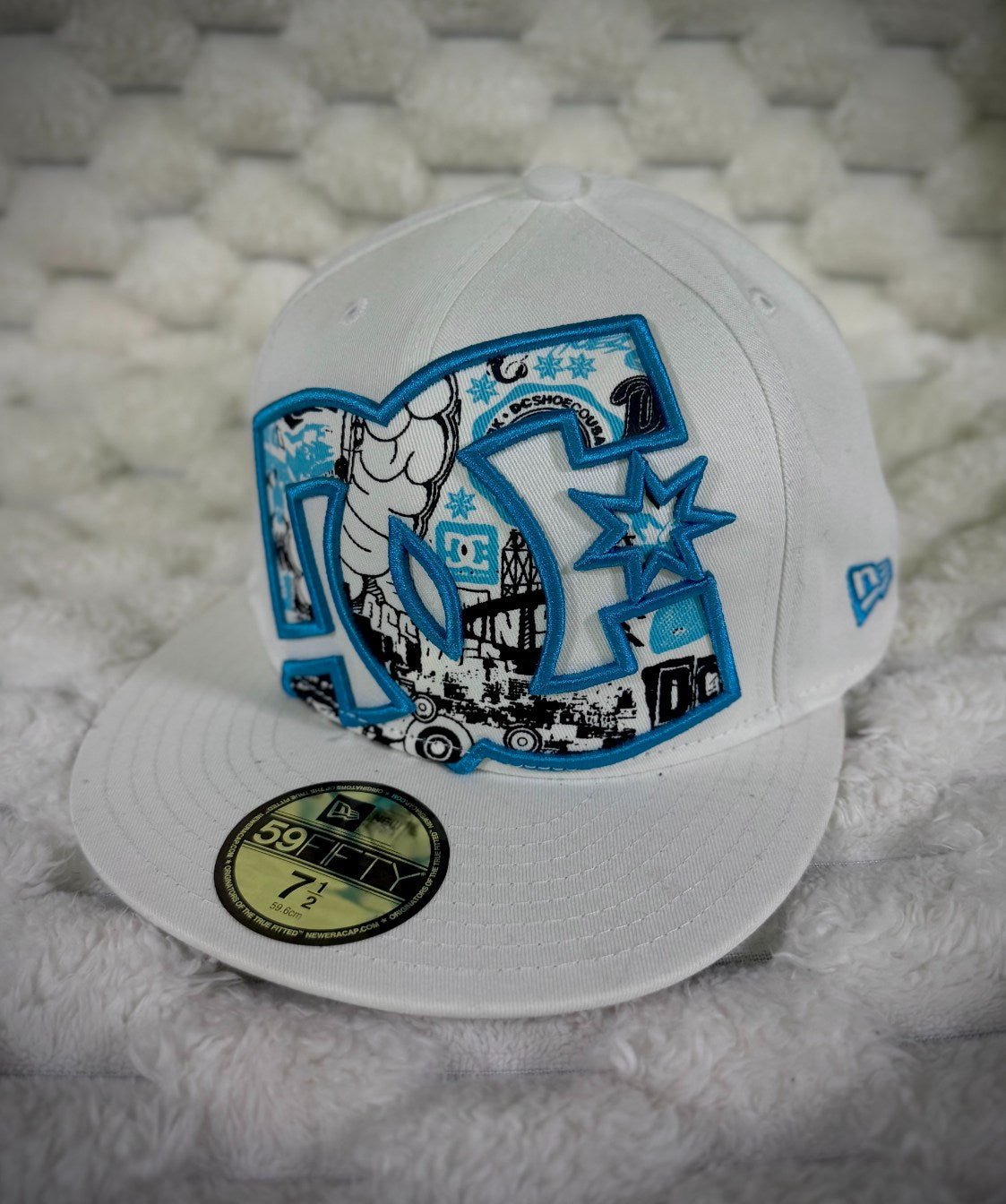 Angled view of vintage DC Shoes 59FIFTY fitted hat showing oversized graphic logo, flat brim and blue New Era side embroidery.