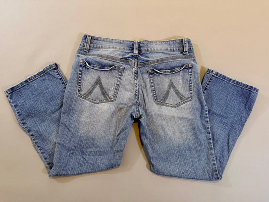 Folded pair of Delia’s bootcut blue jeans 