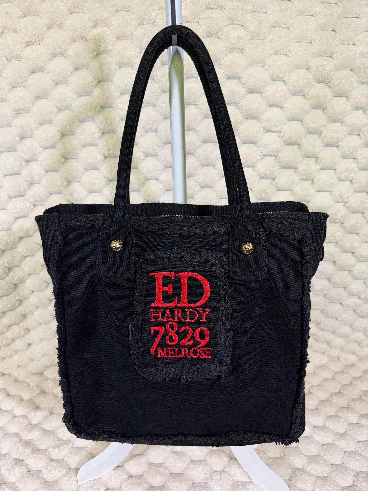 Back of vintage Ed Hardy canvas tote featuring embroidered Ed Hardy Melrose graphic and distressed trim.