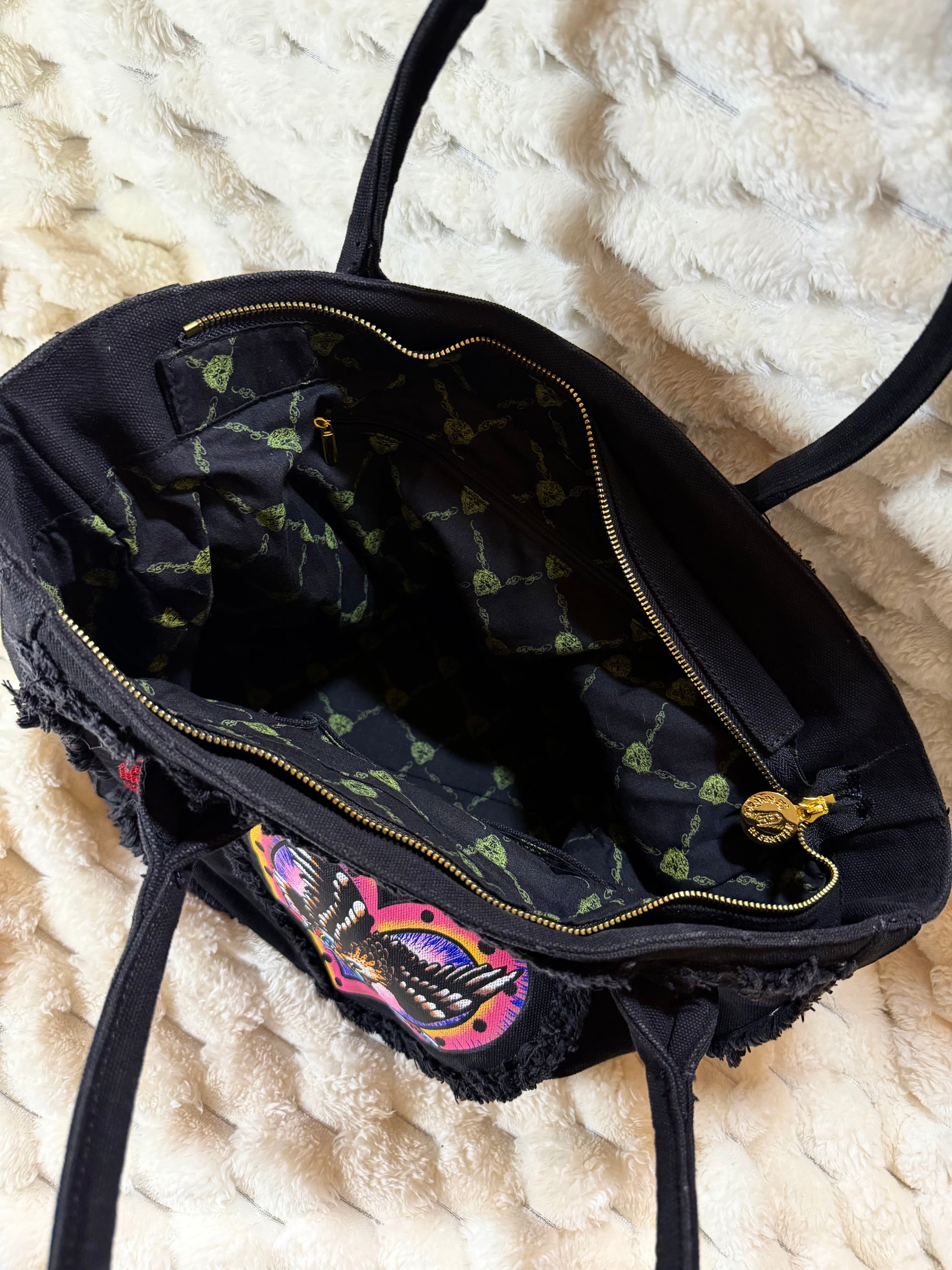 Pristine Interior of Christian Audigier Ed Hardy tote with logo print lining, zipper pocket and slip pockets.