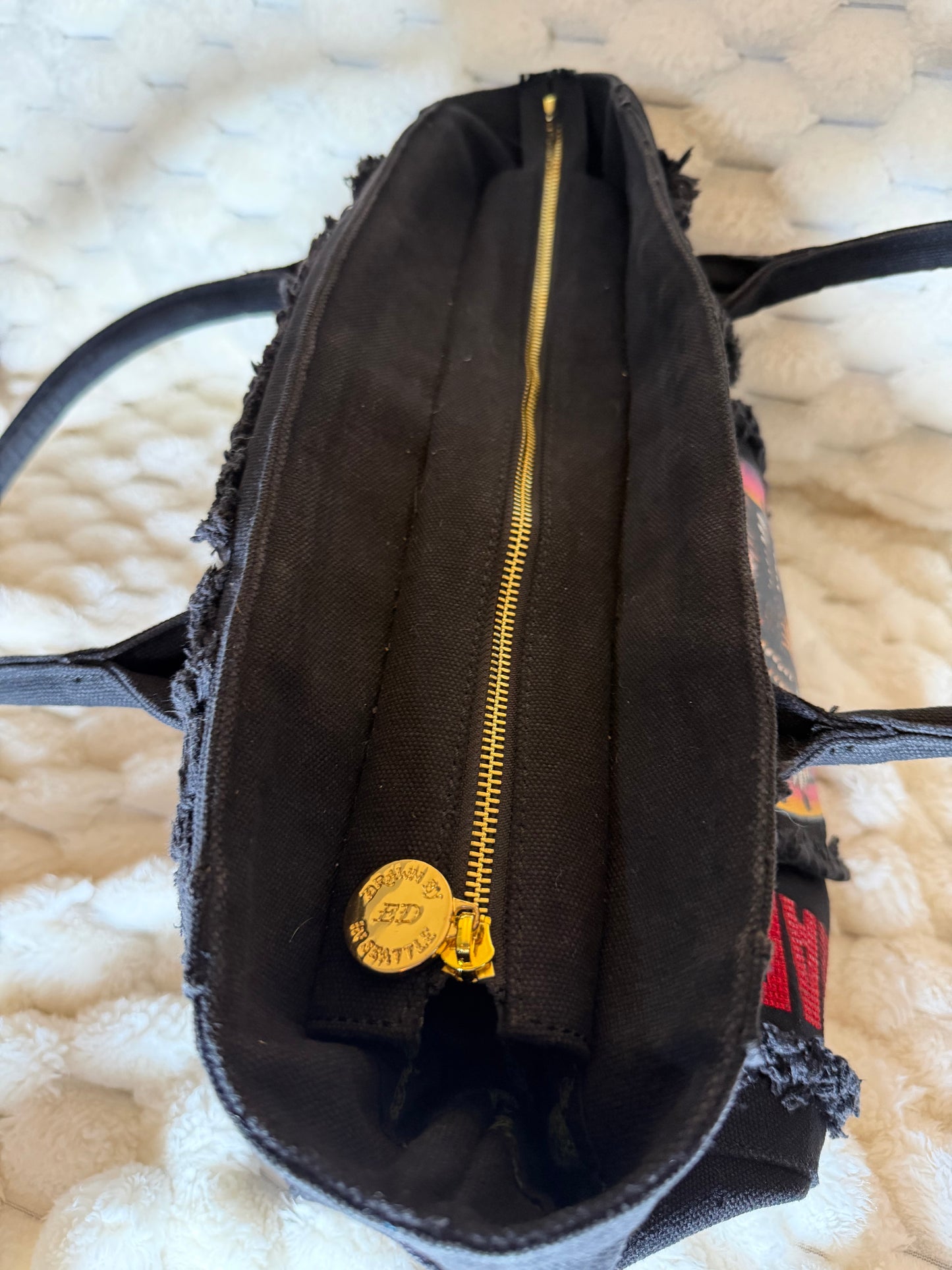 Gold zipper closure with custom Ed Hardy zipper pull on black canvas tote bag.