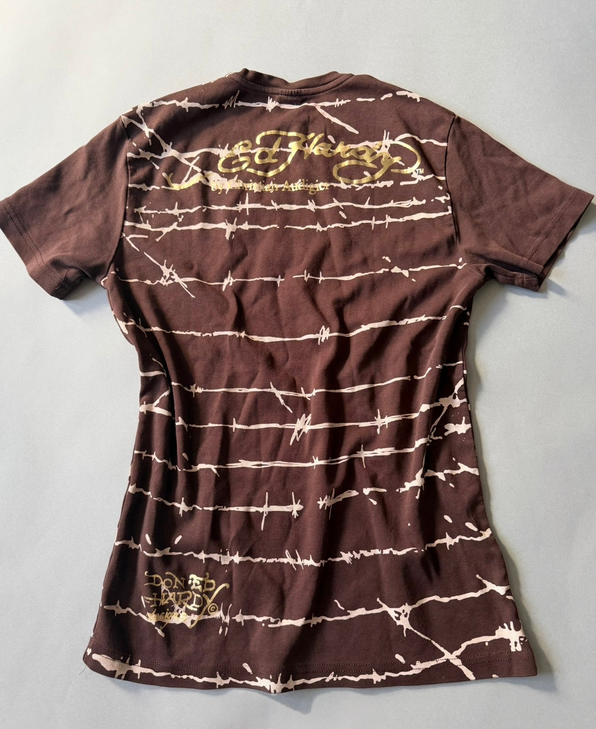 Back view of Y2K era Ed Hardy shirt showing gold foil printed logo branding. 