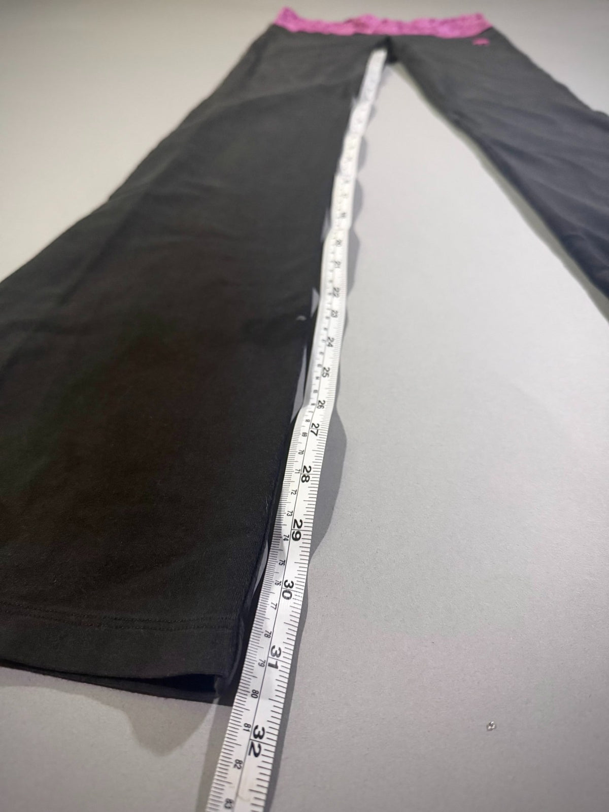 Measuring tape showing inseam on Y2K flare yoga pants. 